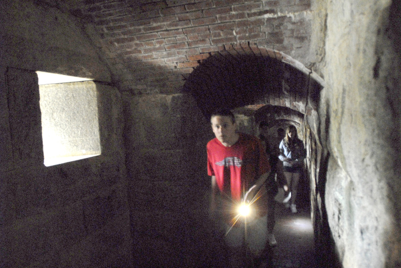 A visitor uses a flashlight on a Fright at the Fort tour of Fort Knox in Prospect.