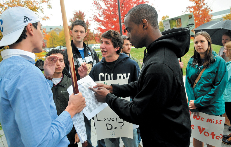 Anti-Diamond protesters Shelby O’Neill, center, a Colby College sophomore, and Uzoma Orchingwa, a Colby senior, right, talk with Colby junior and counterprotester Steve Carroll, left, outside the Diamond Building during Saturday’s protest on the college green.