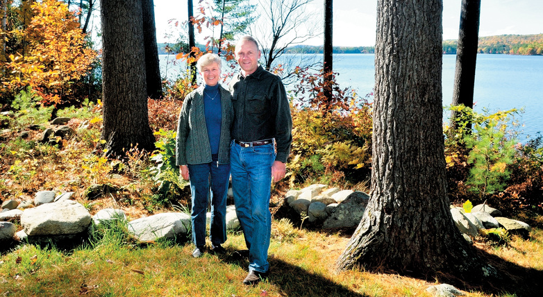 Phyllis and Lynn Matson stand beside a wooded buffer zone between their home and Long Pond in Rome. The buffer helps restict erosion that contains phosphorus and other nutrients that can adversely affect the water. The Matsons received a LakeSmart award for their efforts.