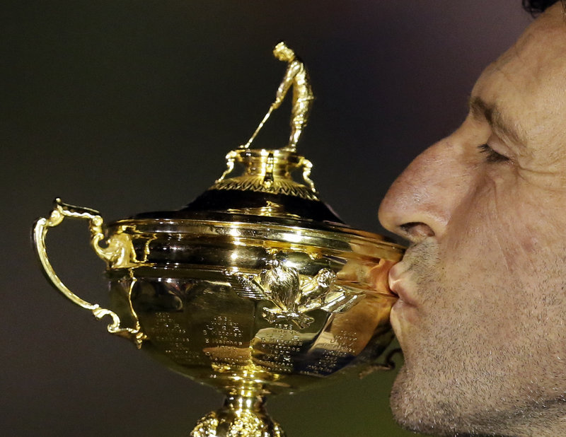 Jose Maria Olazabal, the European team captain, plants a kiss on the trophy after an amazing comeback.