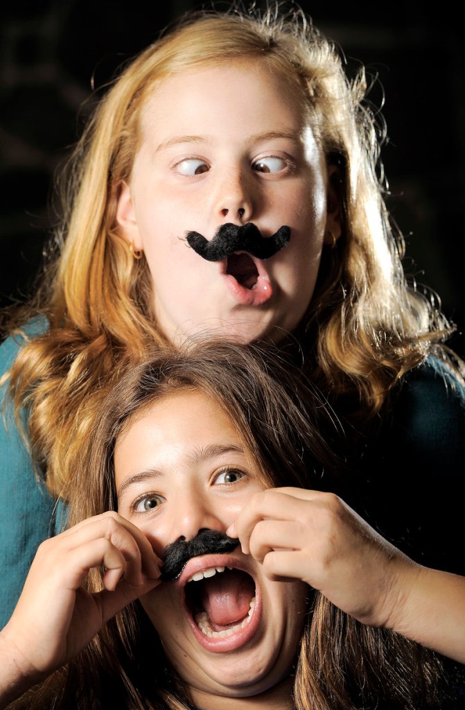 Sarah Rabinowitz, top, and Sydney Pearl, sixth-graders at Falmouth Middle School, are heavily into the mustache craze and say they regularly wear fake staches to school. They own T-shirts, magnets, wallets, duct tape and other items with a mustache theme.