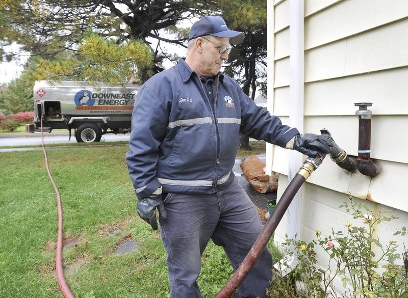 John Patriquin/Staff Photographer Tom O’Connell of Downeast Energy delivers heating oil to a residence on Washington Avenue in Portland on Wednesday. The statewide average price for heating oil is now at $3.68 a gallon, according to the Governor’s Energy Office.