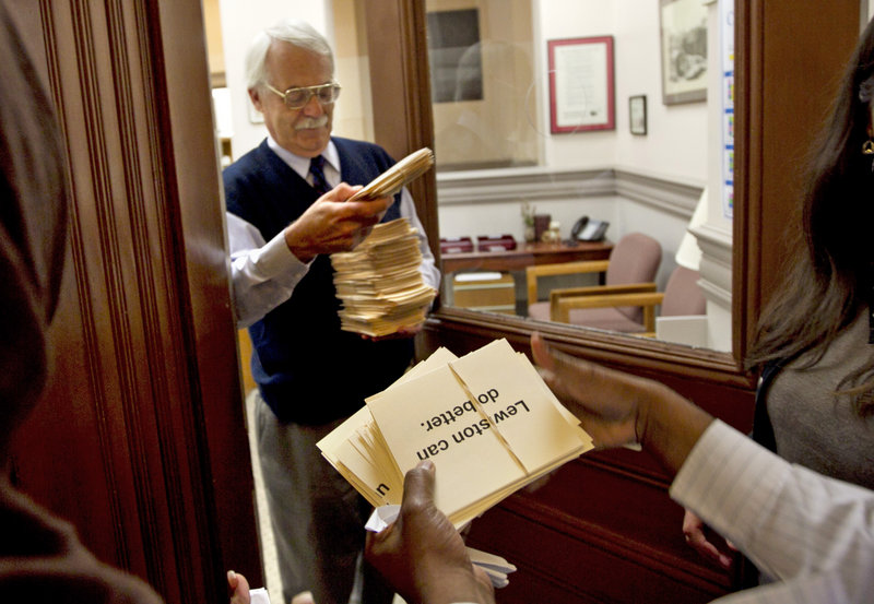 Petitions asking for his resignation of the mayor of Lewiston, Maine, are delivered City Administrator Ed Barrett, Thursday, Oct. 4, 2012, in Lewiston, Maine. Many community members are upset about comments the mayor made about Somali refugees in his city. (AP Photo/Robert F. Bukaty)