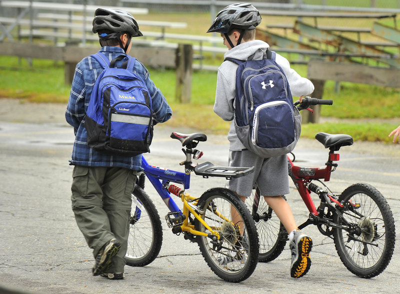 Two students head to the bicycle lock-up area after pedaling to the Portland school.