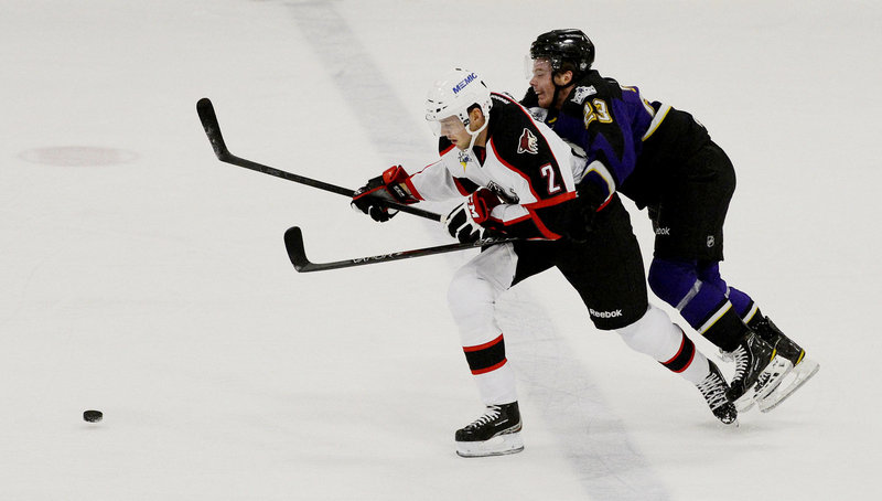 Pirates defenseman David Rundblad chases the puck ahead of Manchester’s Brian O’Neill, who scored the overtime goal that gave the Monarchs a 4-3 preseason win Sunday at Portland Ice Arena.