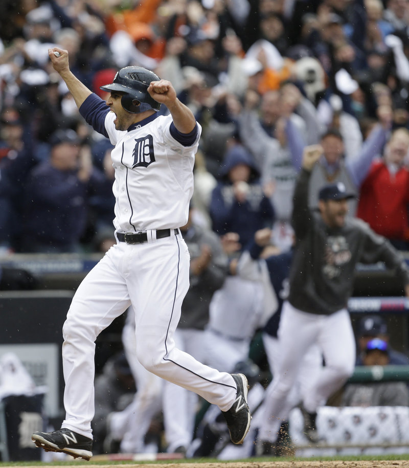 Detroit’s Omar Infante crosses the plate with the winning run in the ninth inning against Oakland, scoring on a sacrifice fly by Don Kelly in a 5-4 win Sunday that gave the Tigers a 2-0 series lead.