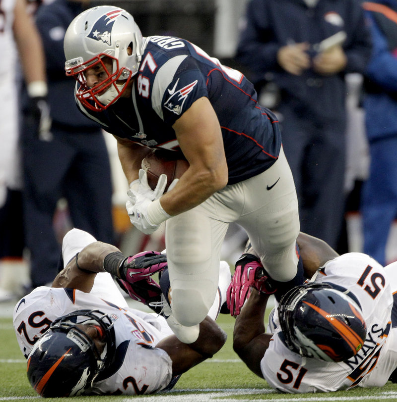 Tight End Rob Gronkowski bulls his way for extra yardage after a second-quarter reception from Tom Brady against the Broncos at Gillette Stadium.