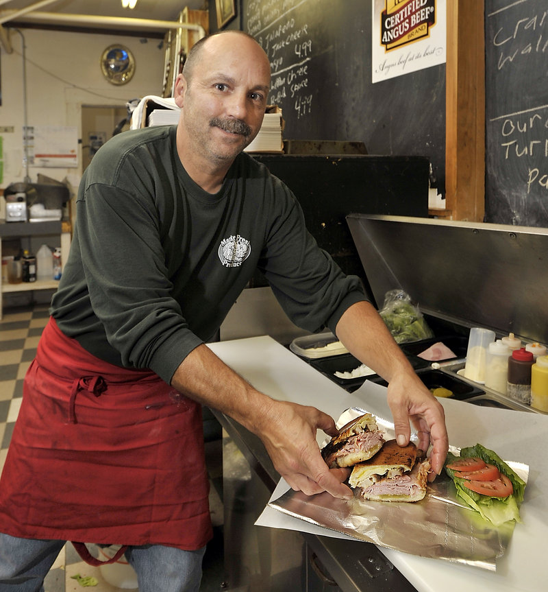 Joe Ruggiero makes a Cuban, the most popular new sandwich at Fresh Approach Market in Portland. It’s grilled, and made with country ham, cured and cooked pork belly, Swiss cheese, pickles and mustard.