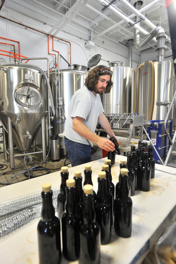 Nathan Sanborn, owner of Rising Tide Brewing Co. in Portland, bottles a special brew of bourbon barrel-aged stout. The company recently moved into a new and larger space and expects to increase production from 149 barrels last year to around 800 this year.