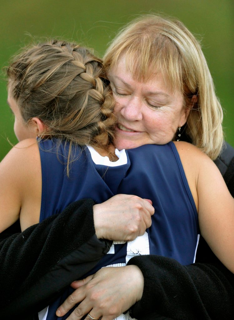 Christina DiPietro gets a hug from her mom, Ann DiPietro, after Fryeburg’s game against Yarmouth late last month. Her daughter’s vision disorder was evident early in life, said Ann DiPietro, who said retinitis pigmentosa has already robbed Christina of her night vision. “That degeneration has been completed.”