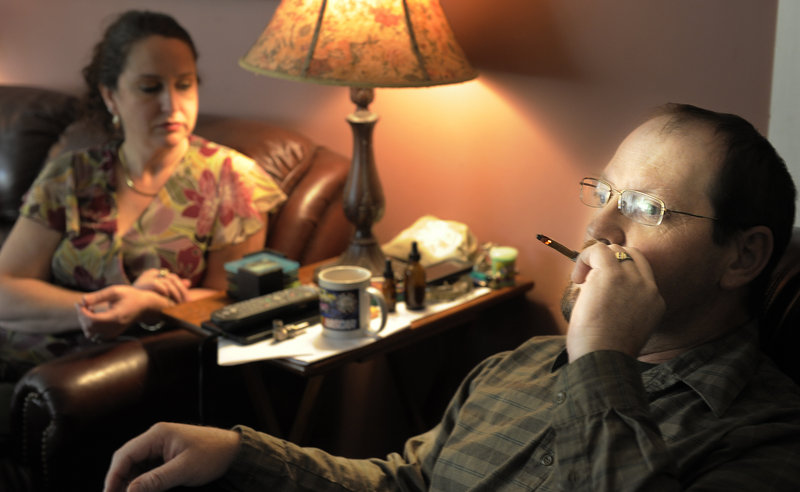 Glenn Lewis smokes medical marijuana in his Manchester home Oct. 9, while recovering from surgery. Both he and his wife, Catherine, sustained what have become recurring injuries after a car crash many years ago, and they treat the injuries with medical marijuana.