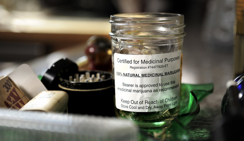 A jar of marijuana labeled “Certified for Medical Purposes” is seen in Catherine and Glenn Lewis’ home. Both use it to treat recurring injuries from a car crash. Once skeptical, Catherine Lewis said she’s now convinced of the drug’s medical benefits.