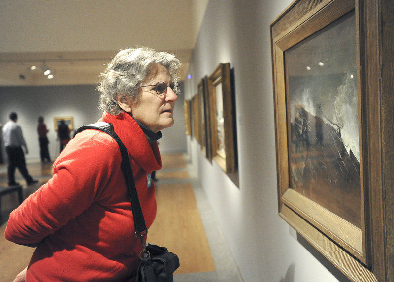 Jane Rosser of Brattleboro, Vt., on Friday takes a close look at Winslow Homer's 1893 oil painting "Coast of Maine," which is included in the Portland Museum of Art's exhibit titled "Weatherbeaten: Winslow Homer and Maine." The museum estimates that 75,000 people will view the show before it closes at the end of the year. Because of its popularity, the exhibition requires advance tickets, and visitation is limited to 60 people each half-hour.