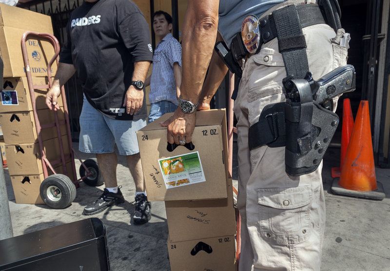 Los Angeles police officers assist Drug Enforcement Administration agents serving a federal warrant to shut down a marijuana dispensary operating in the Chinatown area of Los Angeles last month.