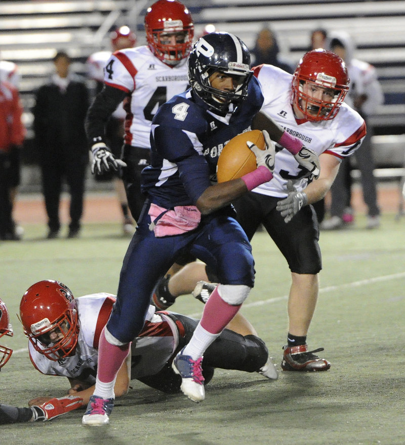 Jayvon Pitts-Young of Portland bursts through a hole in the line and gains extra yardage against Scarborough.