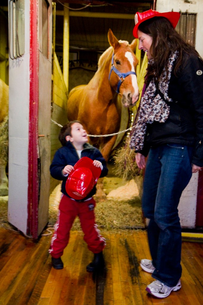 Oscar Goss, 4, of Portland talks with his mother, Stephanie, during an open house at the Portland Fire Museum on Saturday. Oscar and his family come to the Spring Street museum often, but he likes the open house because of the “neigh-neighs,” his name for the horses.