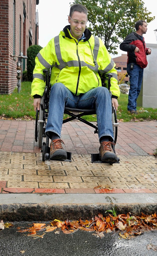 Andrew Allen, an assistant traffic engineer, encounters a high curb at a crossing off Franklin Street while using a wheelchair.