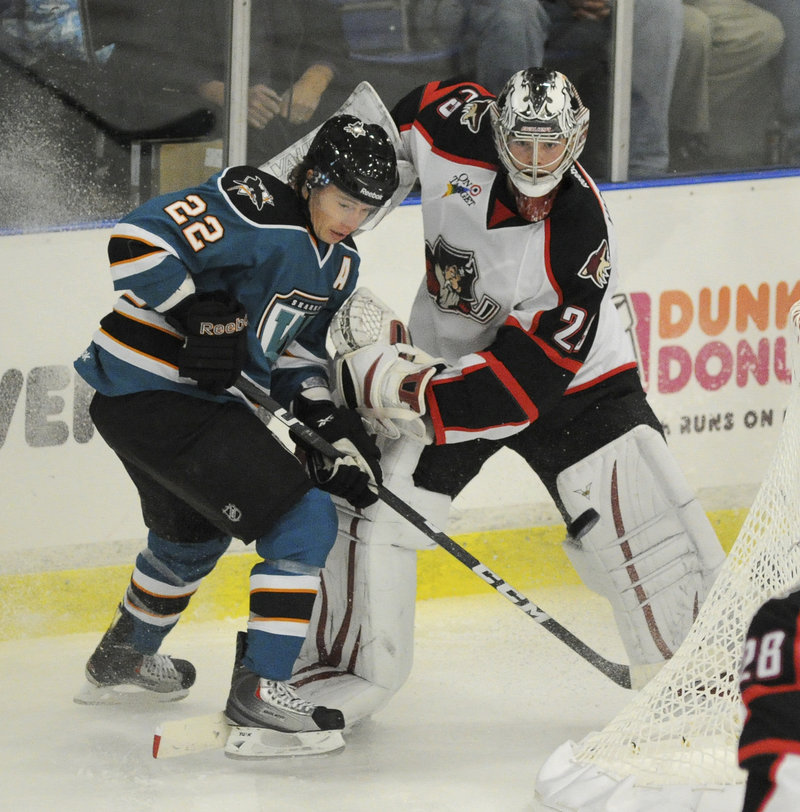 Tim Kennedy, a former Pirate who now plays for the Worcester Sharks, battles for the puck behind the night with Portland goalie Mark Visentin.