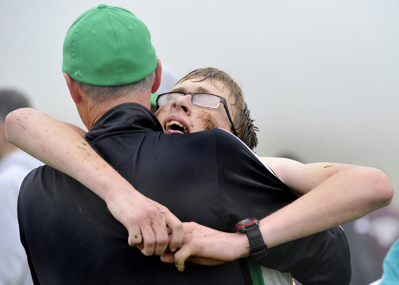 An exhausted Remington Gaetjens is supported by Coach Mark Crepeau after helping Massabesic win in Class A.