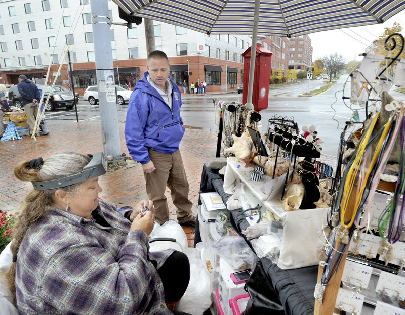 Chuck Fagone, Portland’s code enforcement officer, patrols vendors, including Crystal Tripp of Bridgton, along Commercial Street on Saturday. Vendors can take up no more than 12 square feet of space while leaving at least 4 feet of sidewalk for pedestrians.