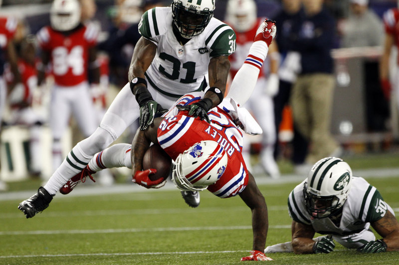 Stevan Ridley heads to the ground after the Patriots running back is hit by Jets cornerback Antonio Cromartie (31) and safety LaRon Landry (30) in the third quarter of Sunday’s AFC East showdown.