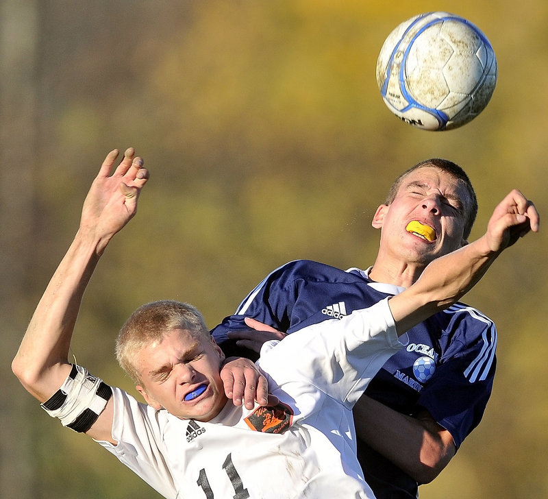 Drew Townsend of Oceanside, right, leaps over Taylor Roy of Winslow to control a header Wednesday during their Eastern Class B boys’ soccer quarterfinal. Winslow won 2-0 at home and will play at Camden Hills in the regional semifinals Saturday.