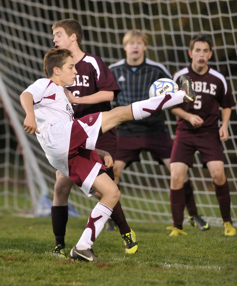 Doug Mitiguy of Greely gets off a difficult shot Wednesday night against the Noble defense during their Western Class A boys’ soccer quarterfinal at Cumberland. Greely won 5-1 and will play Saturday at unbeaten Scarborough in a regional semifinal.