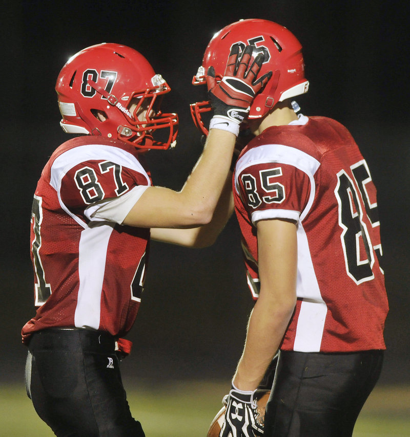 Scarborough’s Chris Cyr, right, is congratulated by teammate Merrick Madden after catching a touchdown pass on fourth down to give the Red Storm a 14-10 lead over Sanford just before then end of the first half.