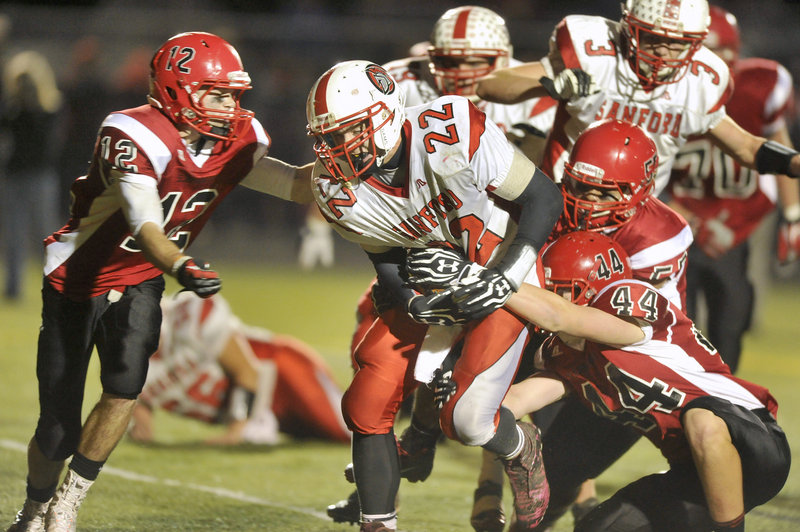 Sanford running back Alex Shain, 22, drags Scarborough defenders for a short gain Friday night. Shain ran for 148 yards, all but 42 in the first half.