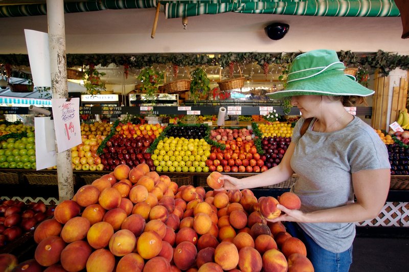 Tara Igoe shops for peaches at a fresh produce stand in Los Angeles. The U.S. Food and Drug Administration says genetically modified foods are safe to eat and don’t need labels, but California voters have a chance to challenge that on Nov. 6.