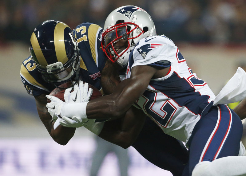 St. Louis Rams wide receiver Chris Givens, left, scores the game’s first touchdown as he is tackled by New England cornerback Devin McCourty during the first half of Sunday’s game in London. The Patriots went on to win, 45-7 and enter their bye weeks with a 5-3 record.