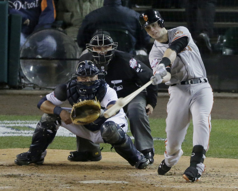 San Francisco’s Marco Scutaro punches a single to center field in the top of the 10th inning, driving home Ryan Theriot with the go-ahead run as the Giants completed a sweep of the World Series with a 4-3 win Sunday night against the Tigers.