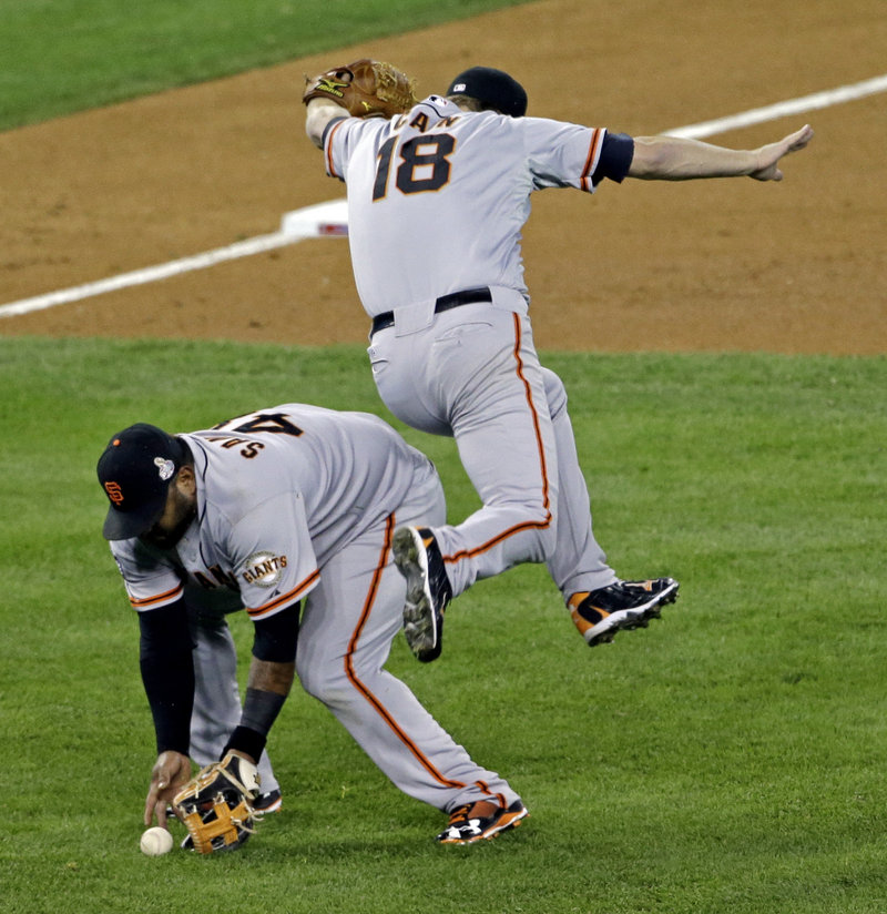 San Francisco pitcher Matt Cain gets out of the way as Pablo Sandoval fields a bunt by Detroit’s’ Quintin Berry during the third inning. Sandoval, who was 8 for 16 with three home runs in the series, was chosen as MVP.