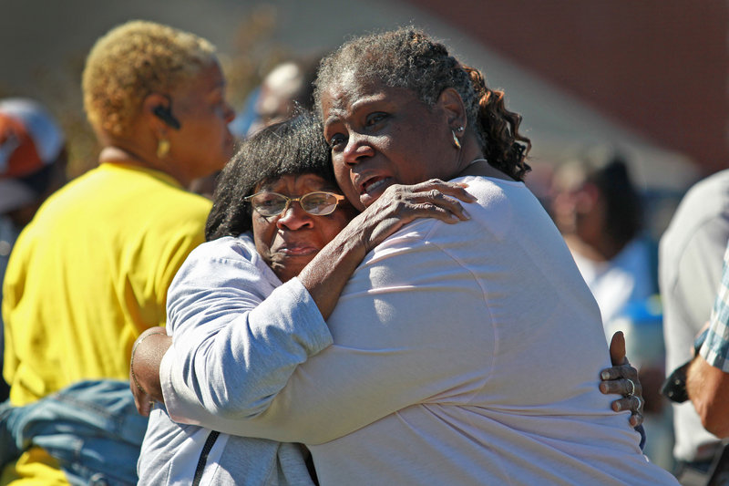 Flora Ford, left, is comforted by a friend outside the Greater Sweethome Missionary Baptist Church in Forest Hill, Texas, on Monday, after the church’s founding pastor was killed by an attacker.
