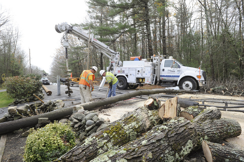 Fairpoint employees Mike Pallozzi and Dennis Buhelt, above and below, replace a utility pole on Methodist Road in Westbrook on Tuesday after Hurricane Sandy rolled through Maine.