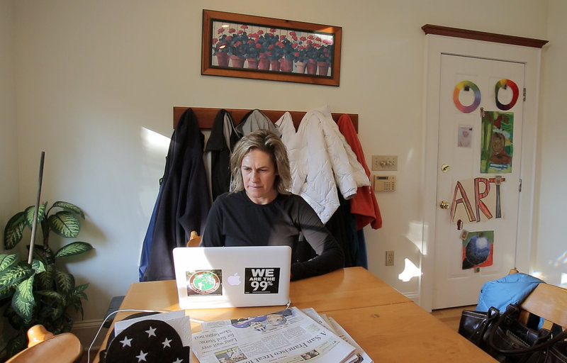 Cynthia Dill checks email on her laptop after returning home from a run in Cape Elizabeth. Each day of campaigning has been different, she says, whether traveling around the state or working from home or meeting voters at various events.