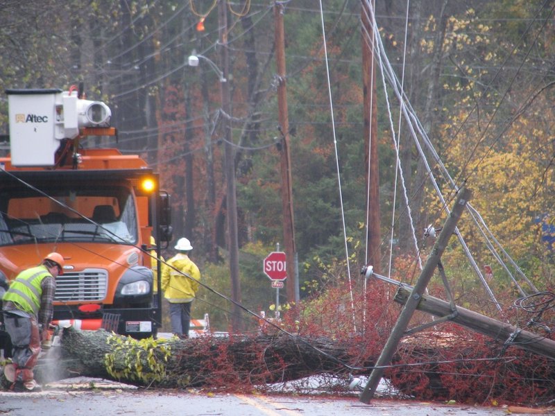 Crews from McDonough Electric Construction of Bedford, Mass., work to remove a cherry tree that had fallen over Princes Point Road in Yarmouth on Tuesday.