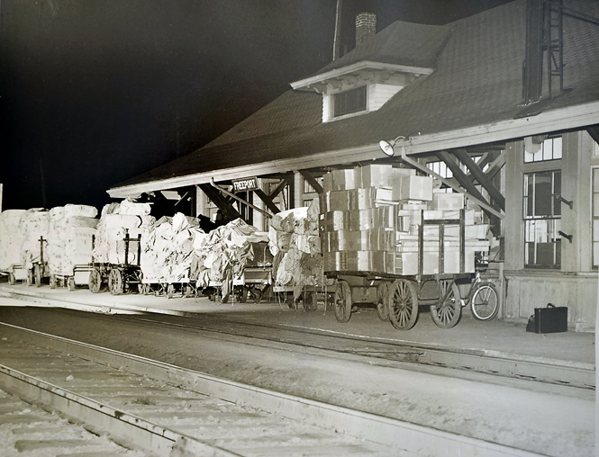 The Freeport train station in 1950, with trucks filled with L.L. Bean packages ready to be loaded onto freight cars.