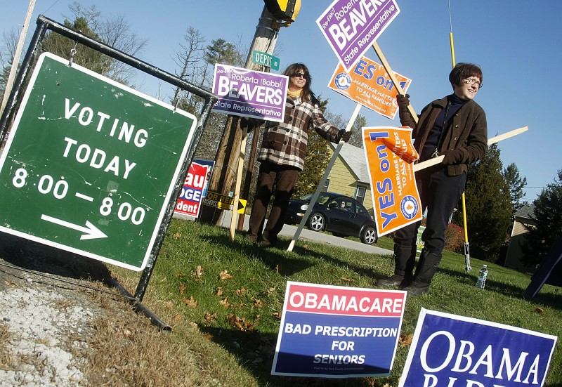 Kim Reed, right, and Michele Duval, both of Eliot, wave signs outside the Marshwood Middle School along Route 236 in Eliot as voters make their way to the polls Tuesday, November 6, 2012. Staff photo/Jill Brady