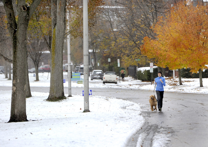 Anya Wilhelmi and her dog Grover avoid the wet snow as they jog along the Western Prom on Thursday morning.