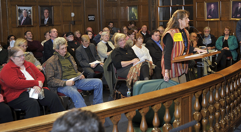 Donna Yellen, advocacy director at Preble Street in Portland, holds the type of mattress on which homeless people sleep, while she address a City Council meeting Monday. The meeting was not the fight some people were expecting between the business community and advocates for the homeless.