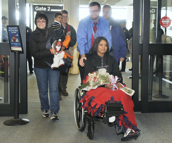 Army Sgt. Helaina Lake along with her mother, Jeannine, left, were met by family and friends as she departed the gate area at Portland Jetport on Tuesday.