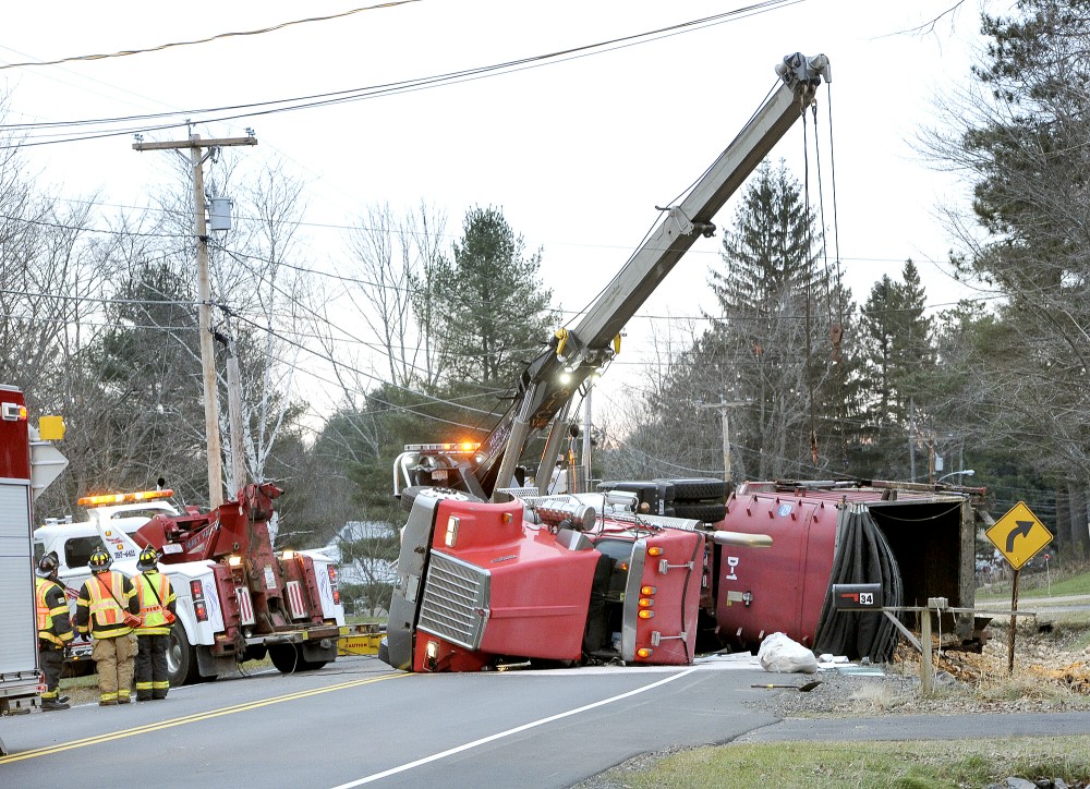 Workers try to upright a trash truck that overturned on Rt. 237 in Gorham early this morning, Tuesday, Nov. 27, 2012 causing traffic to be re-routed around the scene.
