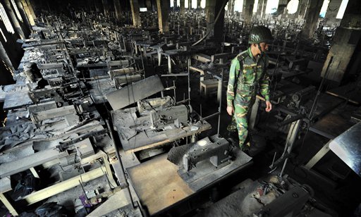 A Bangladeshi police officer walks between rows of burnt sewing machines in a garment factory outside Dhaka, Bangladesh on Sunday. At least 112 people were killed in a late Saturday night fire that raced through the multi-story garment factory just outside of Bangladesh's capital.