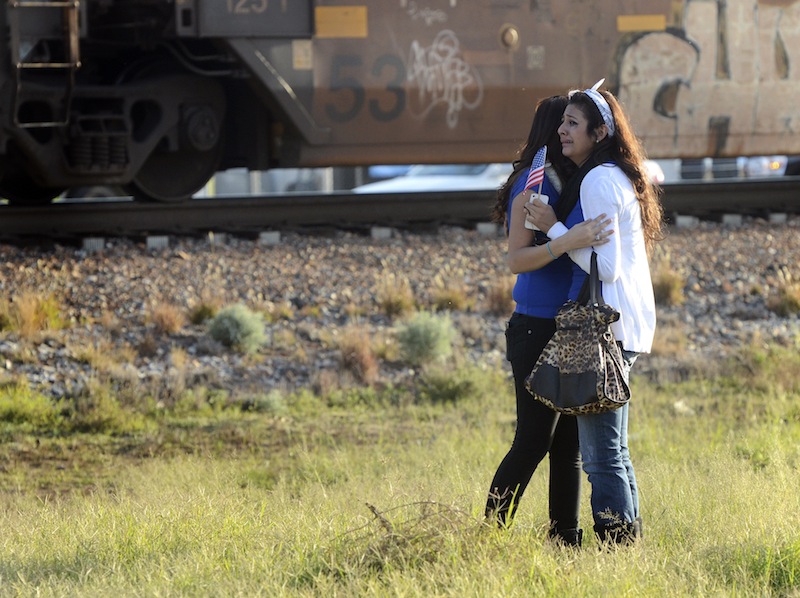Parade participants react after a trailer carrying wounded veterans in a parade was struck by a train in Midland, Texas, Thursday, Nov. 15, 2012. "Show of Support" president and founder Terry Johnson says there are "multiple injuries" after a Union Pacific train slammed into the trailer, killing at least four people and injuring 17 others. (AP Photo/Reporter-Telegram, James Durbin) MRT;accident;wreck;crash;armed forces