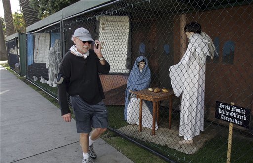 A man walks past two of the traditional nativity scenes at Palisades Park in Santa Monica, Calif., in December 2011. The city eliminated the holiday tradition this year rather than see a repeat of disputes and vandalism related to competing messages of Christians and atheists.