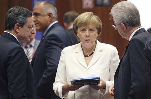 German Chancellor Angela Merkel, center, speaks with European Central Bank President Mario Draghi, left, and Italian Prime Minister Mario Monti during a round table meeting at a EU Summit in Brussels in June.