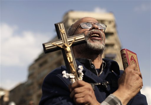 An Egyptian protester chants slogans and holds a cross and a Quran in Tahrir Square on Frida. Supporters and opponents of Egypt's Islamist President Mohammed Morsi staged rival rallies Friday after he assumed sweeping new powers, a clear show of the deepening polarization plaguing the country.