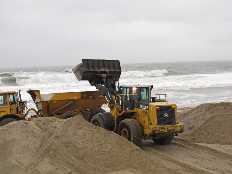 Workers use heavy equipment to hurriedly push piles of sand back onto the beach in Point Pleasant Beach, N.J., on Wednesday as a nor'easter was hitting.