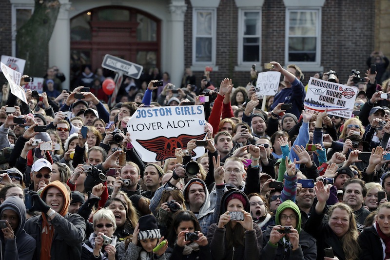 Fans line up along Commonwealth Avenue, Monday, Nov. 5, 2012 in Boston's Allston neighborhood to watch a free concert by Aerosmith whose band members lived there in the early 1970's. (AP Photo/Elise Amendola)